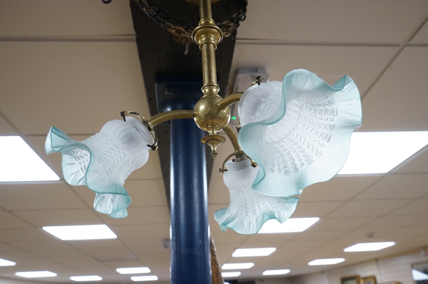A brass three branch frosted shade ceiling light